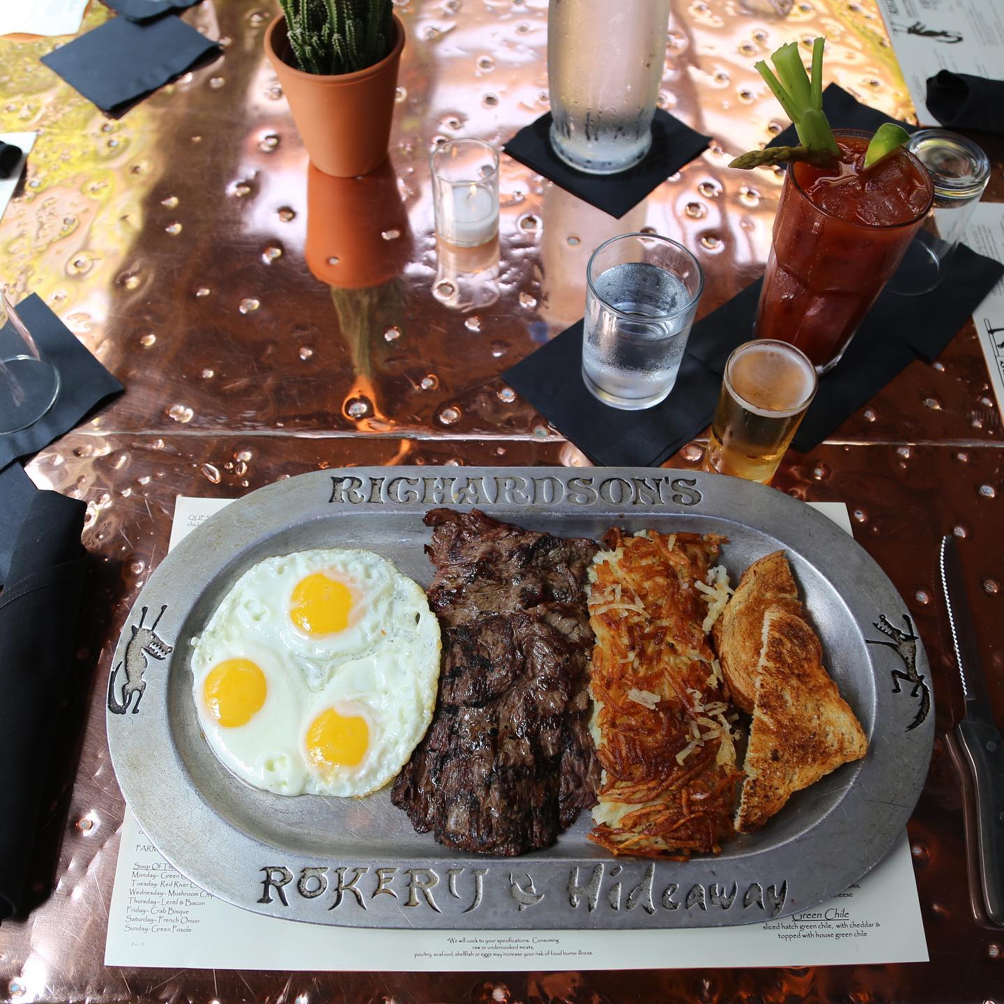 Steak and eggs with hashbrowns and toast on a copper tabletop